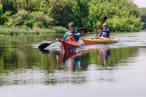 Unga familje flottar på en lugn vacker flod på två kajaker — Stockfoto