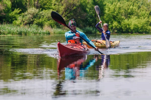 Giovani zattere di famiglia su un bellissimo fiume tranquillo su due kayak — Foto Stock