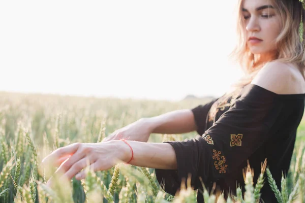 Młoda, szczupła dziewczyna w wieńcu z kłosami pszenicy o zachodzie słońca na polu — Zdjęcie stockowe