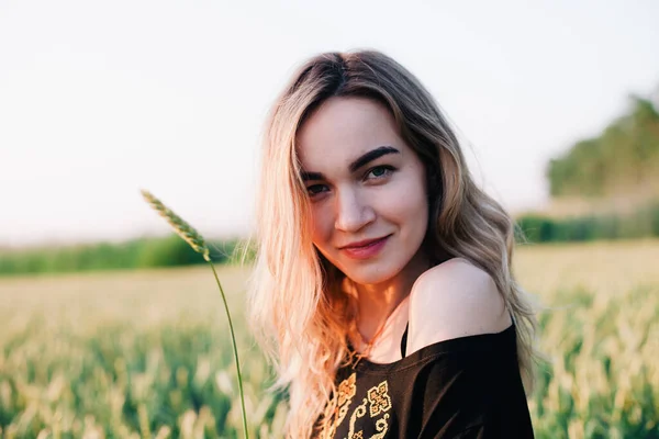 Jeune fille mince robe brodée dans un grand champ de blé au coucher du soleil — Photo