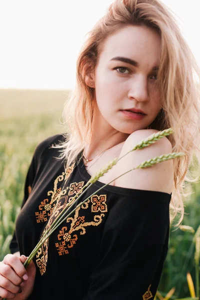 Young, slender girl embroidered dress in a large wheat field at sunset — Stock Photo, Image