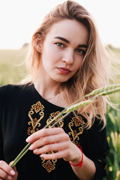 Jeune fille mince robe brodée dans un grand champ de blé au coucher du soleil — Photo