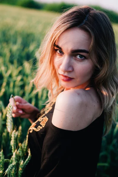 Jeune fille mince robe brodée dans un grand champ de blé au coucher du soleil — Photo