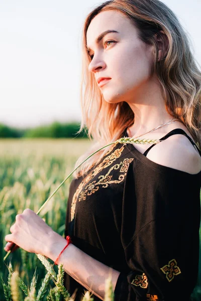 Νεαρό, λεπτό κορίτσι κεντημένο φόρεμα σε ένα μεγάλο χωράφι με σιτάρι στο ηλιοβασίλεμα — Φωτογραφία Αρχείου
