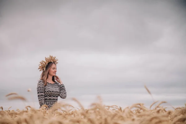 Güzel, ince bir kız buğday tarlasında yağmurlu gökyüzüne karşı — Stok fotoğraf