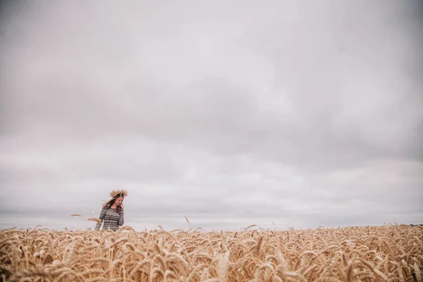 Όμορφη, λεπτή κοπέλα σε ένα χωράφι με σιτάρι ενάντια στον ουρανό της βροχής — Φωτογραφία Αρχείου