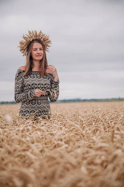 Vacker, smal flicka på ett vetefält mot regnskyn — Stockfoto