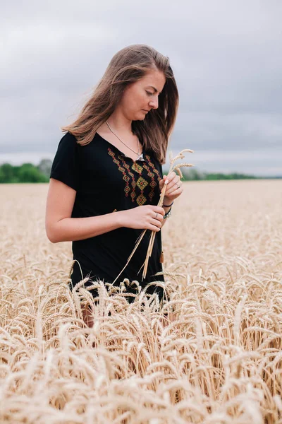Озил, стройная девочка в поле пшеницы на фоне дождливого неба — стоковое фото