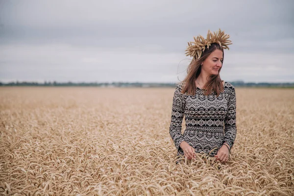 Vacker, smal flicka på ett vetefält mot regnskyn — Stockfoto