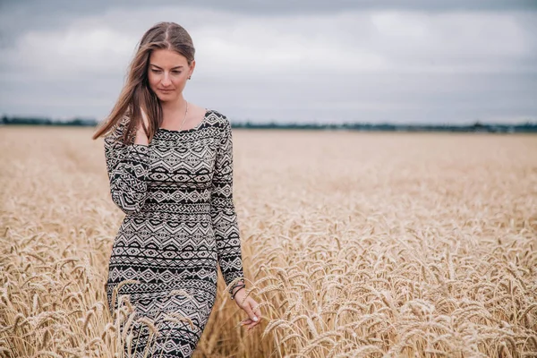 雨の空に対して小麦の分野で美しく、ほっそりした女の子 — ストック写真