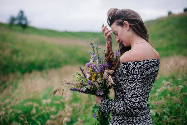 Schöne, schlanke Mädchen in einem Wiesenkleid mit Wildblumen — Stockfoto