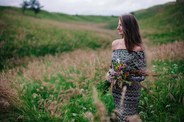 Schöne, schlanke Mädchen in einem Wiesenkleid mit Wildblumen — Stockfoto