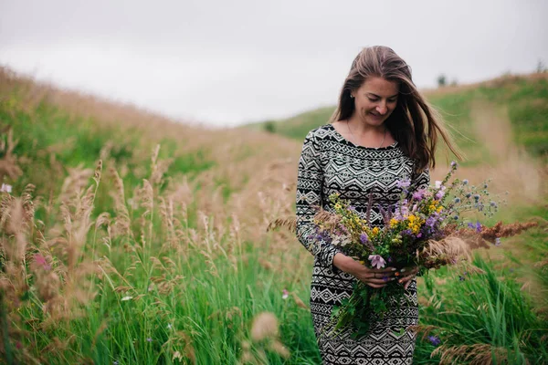 Schöne, schlanke Mädchen in einem Wiesenkleid mit Wildblumen — Stockfoto