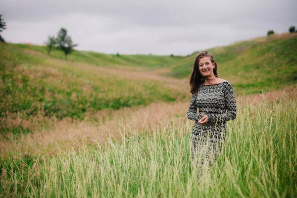 Vacker, smal flicka i en äng klänning med vilda blommor — Stockfoto