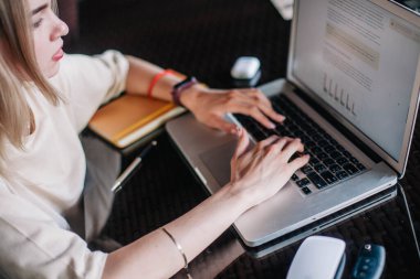 Restoran masasındaki ince kız dizüstü bilgisayarın arkasında çalışıyor.