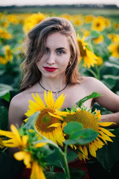 Молода струнка дівчина без одягу вкрита соняшниками — стокове фото