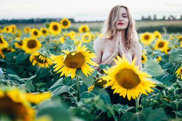 Giovane, sottile ragazza in topless posa al tramonto in un campo di girasoli — Foto Stock