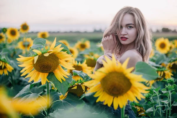 Giovane, sottile ragazza in topless posa al tramonto in un campo di girasoli — Foto Stock