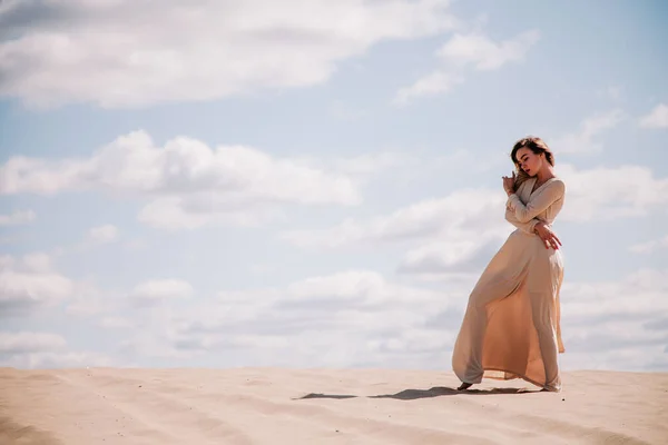 Młoda, szczupła dziewczyna w beżowej sukience spaceruje po pustyni — Zdjęcie stockowe