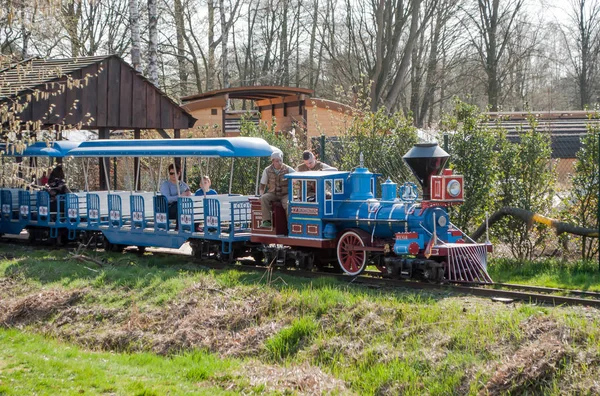 Atracción en el parque de recreo - un tren para niños en los rieles con una locomotora y carruajes. Parque del Serengeti en Alemania . — Foto de Stock