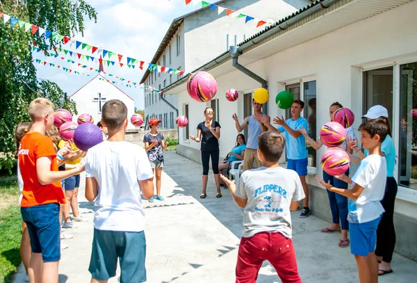 Tonåringar, samtidigt kastar bollen i en cirkel i ett sportspel, teambuilding — Stockfoto