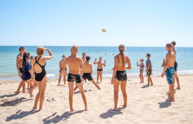 Yaz kampında plajda voleybol oynayan gençler
