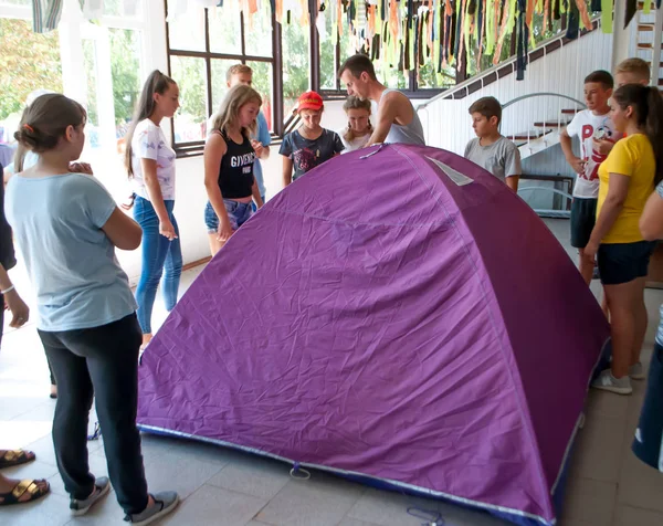 L'istruttore insegna agli adolescenti a montare una tenda nel campo estivo — Foto Stock