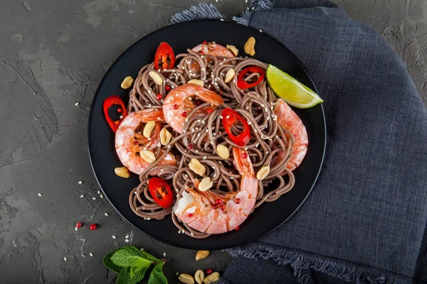 Koyu taş backgrou üzerinde kase karides ile Udon kızarmış noodle