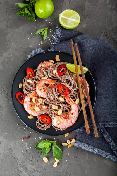 Koyu taş backgrou üzerinde kase karides ile Udon kızarmış noodle