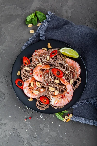 Koyu taş backgrou üzerinde kase karides ile Udon kızarmış noodle