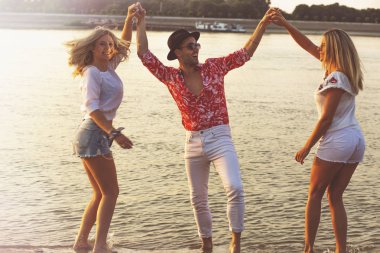 Sahilde birlikte dans eden arkadaşlar. Plajda eğlenen mutlu gençler. 