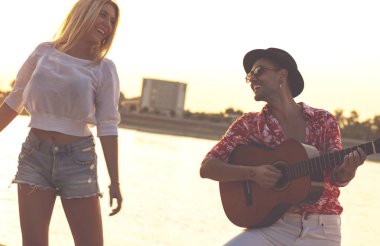 Sahilde birlikte dans eden arkadaşlar. Plajda eğlenen mutlu gençler. 