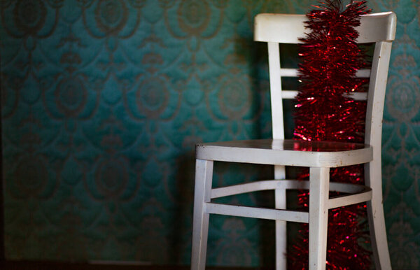 Winter. Christmas decoration on a rustic chair.Christmas ornament, red - gold color,  with shining lamps.