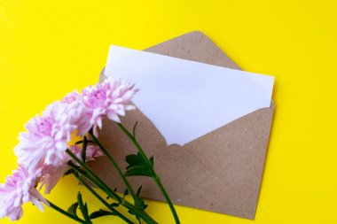 Parlak sarı baklava üzerinde boş mektup ve pembe krizantem çiçekleri ile Aşk zarfı. Kopyalama alanı