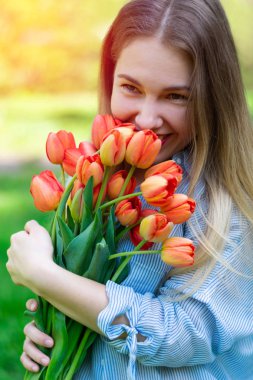 Genç güzel beyaz gülümseyen kadın kırmızı lale bir buket tutuyor, kalma, düğün günü, dikey