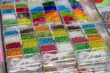Bir sürü renkli cam boncuklu konteynır. El işi ve hobi için. Mücevher yapmak için çok renkli boncuklarla dolu kutular.