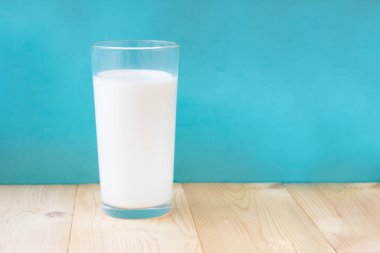 Mavi arka planda bir bardak taze süt. Nesne.