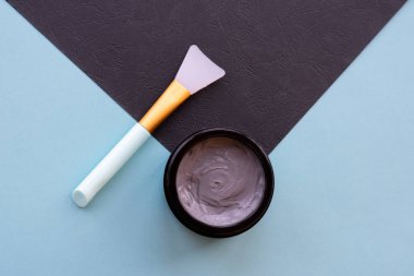 Yüz ve vücut için açık gri çamur maskesi kavanozu naneli ve siyah arka planda yumuşak fırçalı. Yüz bakımı ve tedavide kullanılan ev yapımı organik ürünler..