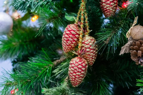 カラフルな輝くコーン ガーランド リボン おもちゃは クリスマスツリーの枝にかかっています パーティーの背景やお祝いのカードとして飾られたクリスマスツリー ロイヤリティフリーのストック画像