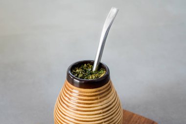 Geleneksel Yerba Mate çay içecek tarafsız taş gri backgrund üzerinde artırılması matero ve bombilla, sağlıklı, enerji ile.