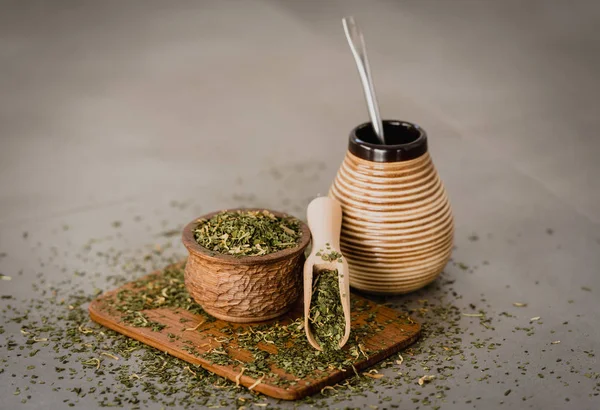 Traditional Yerba Mate tea with matero and bombilla, healthy, energy boosting beverage drink on neutral stone gray backgrund.