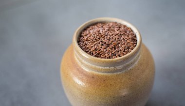Keten tohumu veya kase sürahi taş gri arka plan üzerinde linseeds. Keten tohumu ya da keten tohumu kavramı. Keten tohumu diyet lifi arka plan