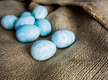 Kahverengi bez arka planda el boyalı Easetr yumurtaları