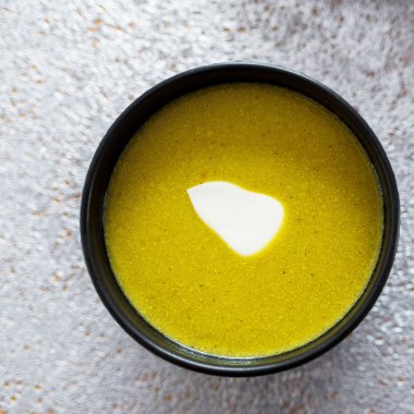 Ahşap masada siyah plaka yeşil brokoli & ıspanak sebze çorbası. Modern mutfak, yemek pişirme ve sağlıklı gıda konsepti. 