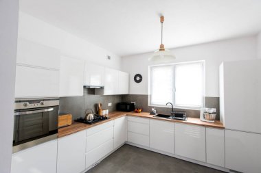 Aksesuarlı vernikli mdf panoları ile Modern beyaz mutfak. Modern livfestyle & pişirme konsepti.