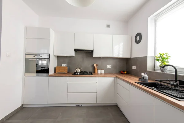 Neat Modern white kitchen with varnished mdf boards, with accessories. Modern livfestyle & cooking concept.