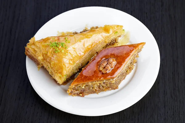 Ceviz ve kakule, ahşap bir masa üzerinde geleneksel Arapça tatlı baklava. Fındık ve bal ile ev yapımı baklava.