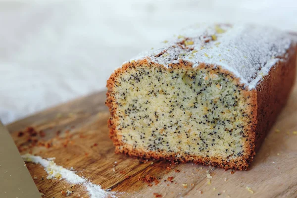 Haşhaş tohumları ve limon suyu ile kek, pudra şekeri serpilir. Ahşap tahta üzerinde limon ile Cupcake.