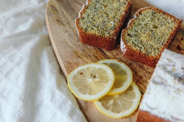 Haşhaş tohumları ve limon suyu ile kek, pudra şekeri serpilir. Ahşap tahta üzerinde limon ile Cupcake.