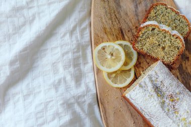 Haşhaş tohumları ve limon suyu ile kek, pudra şekeri serpilir. Ahşap tahta üzerinde limon ile Cupcake.